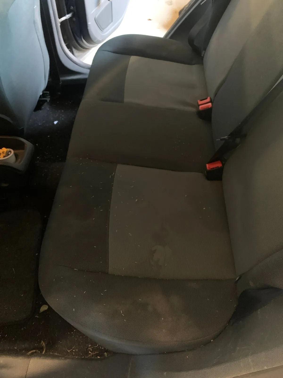 Banquette arrière en tissu tachée et couverte de miettes avant nettoyage