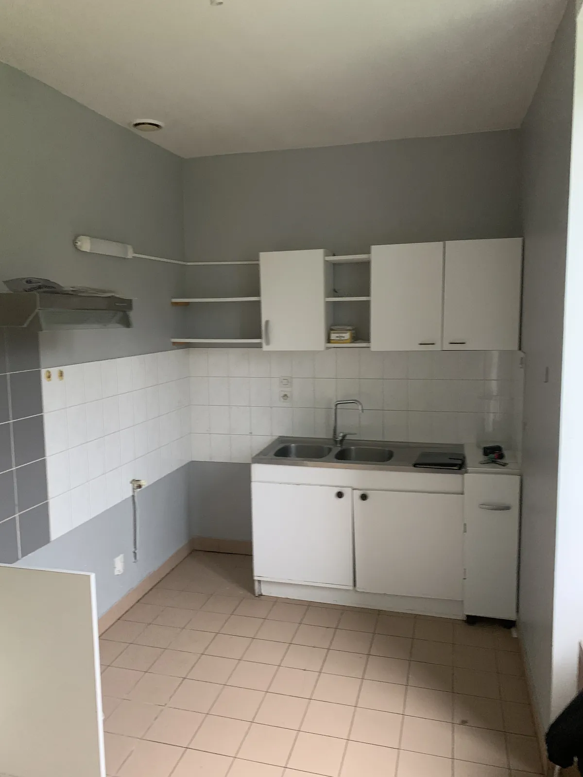 Cuisine de l'appartement à Tarare avant travaux, murs tachés et ancienne cuisine abîmée